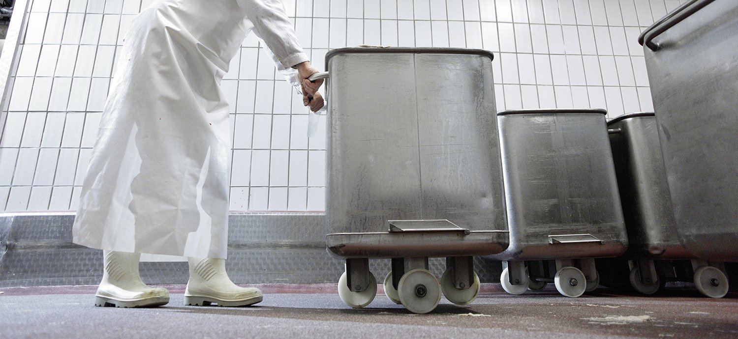 Mitarbeiter schiebt Bottich