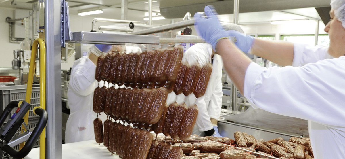 Entnahme von Wurststangen am Rauchwagen