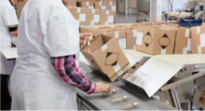 Ein Fabrikarbeiterin räumt Kartons ein